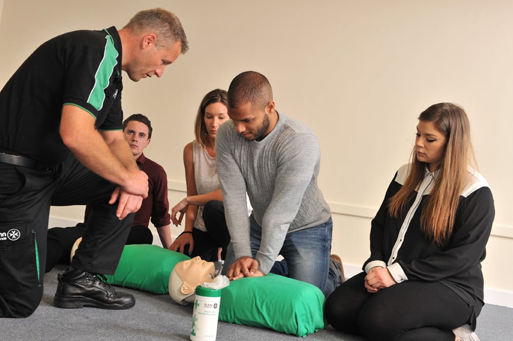 A group of first aid students learning about CPR.