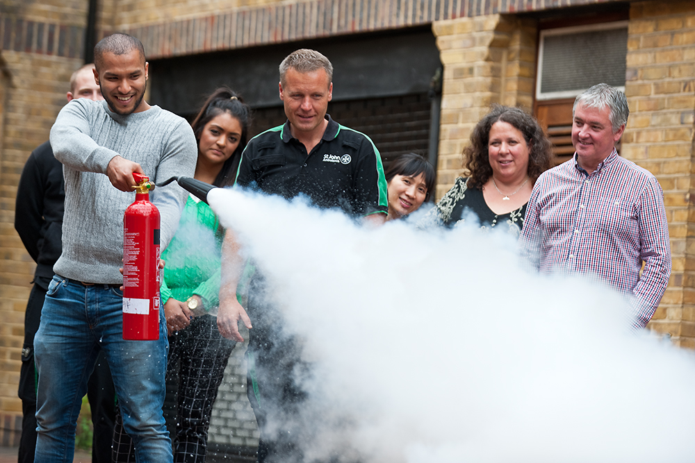 Group observes course delegate practising with a fire extinguisher