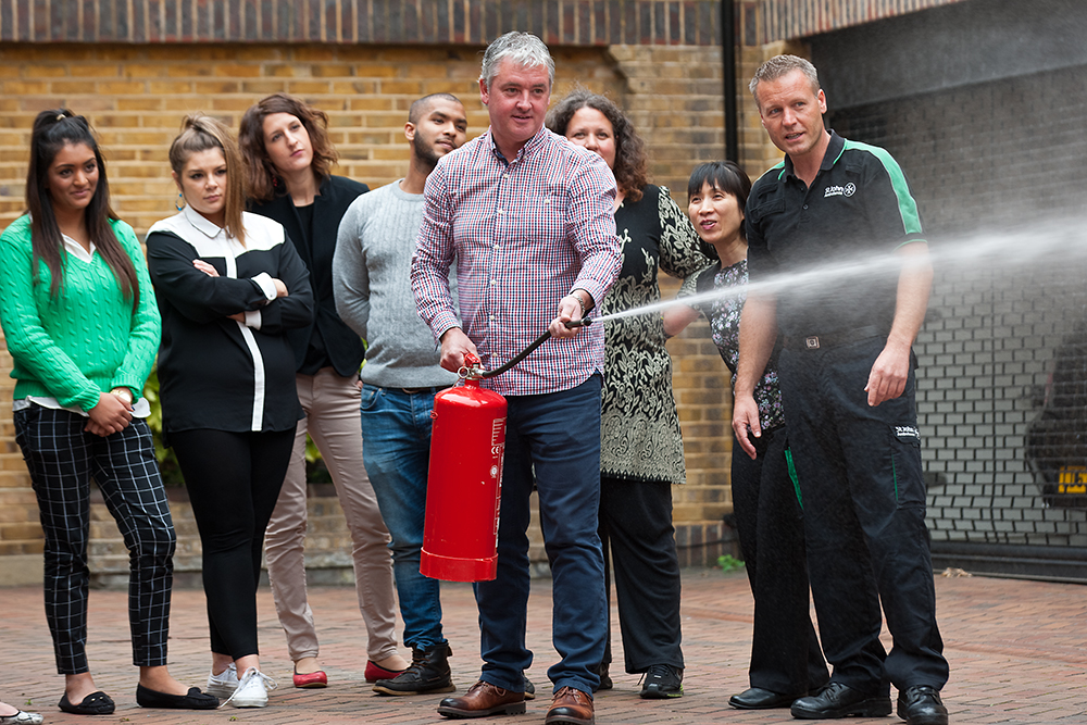 Course group watches demonstration of using a fire extinguisher