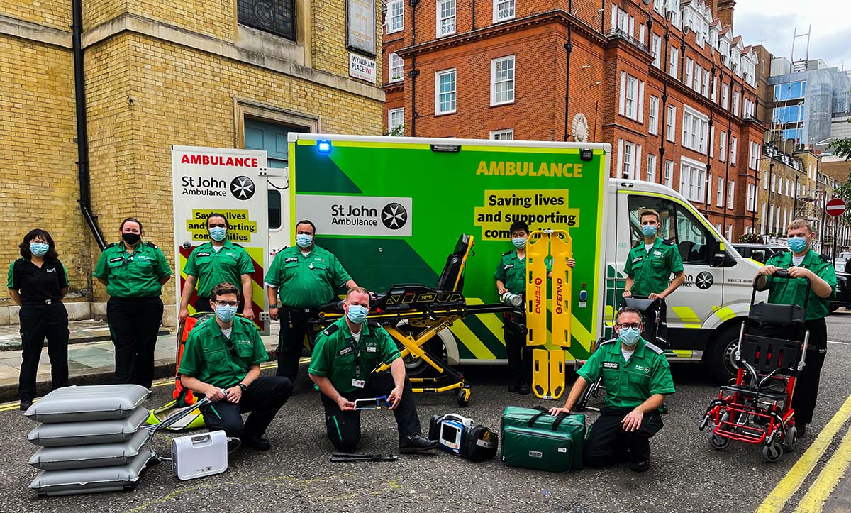 St John Ambulance staff with equipment standing outside a St John Ambulance box body ambulance
