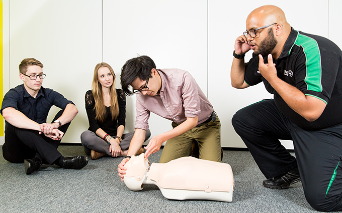 A group of first aid students learning about CPR.